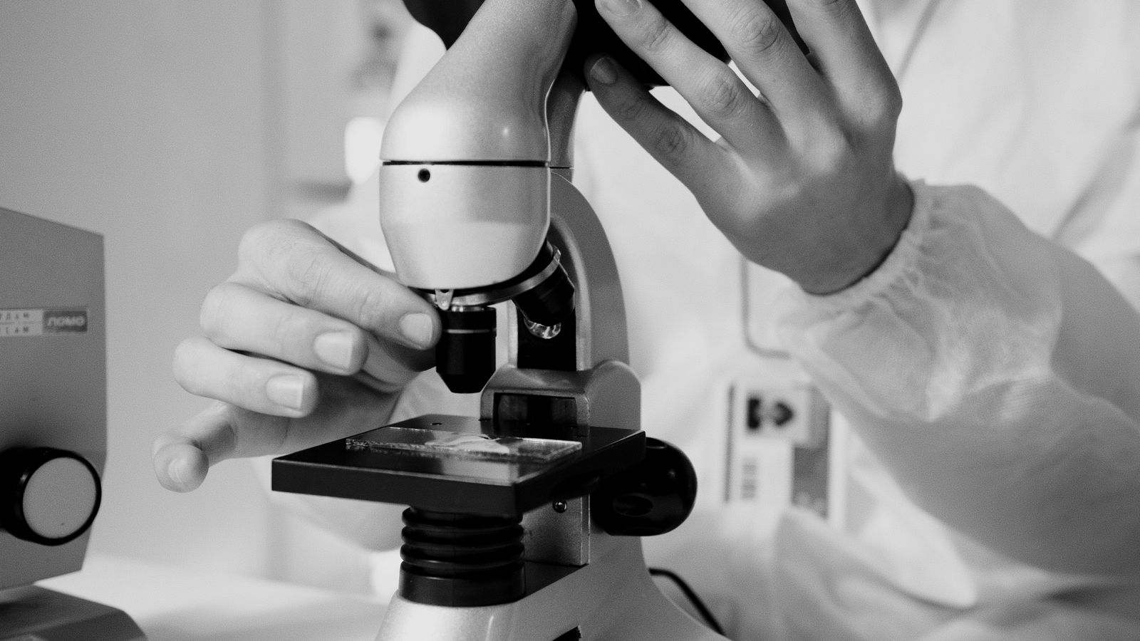 Scientist using a research microscope